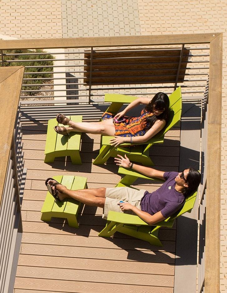 two students sit on the balconly of pitzer hall